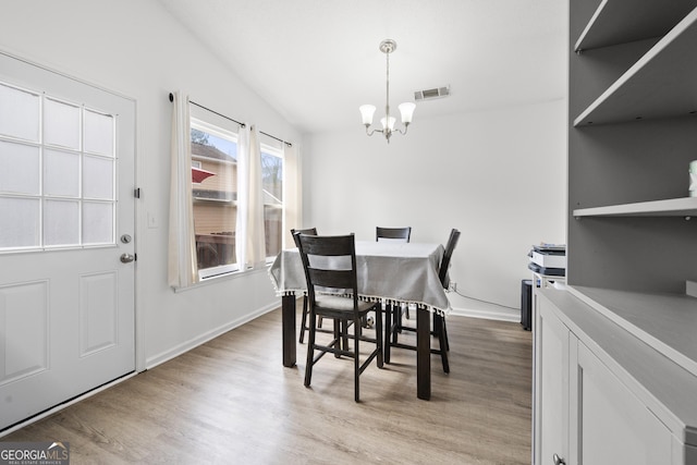 dining room with light hardwood / wood-style flooring and a notable chandelier