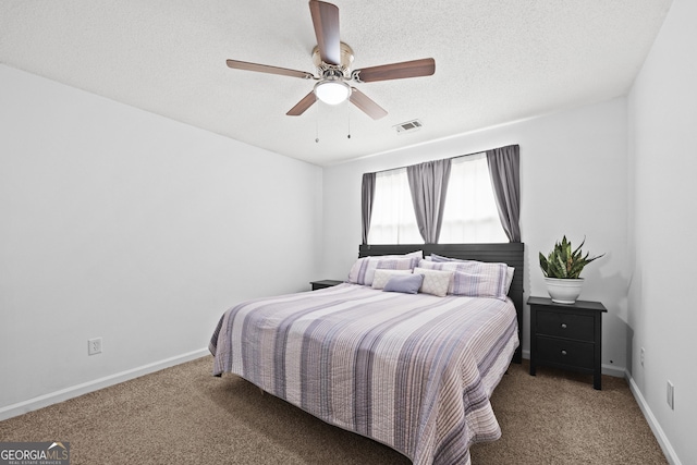 bedroom with ceiling fan, a textured ceiling, and carpet flooring