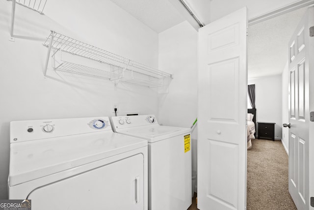 clothes washing area with separate washer and dryer and carpet