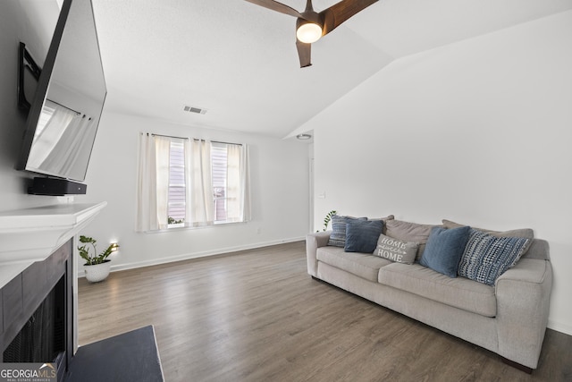 living room featuring ceiling fan, lofted ceiling, a high end fireplace, and dark hardwood / wood-style floors