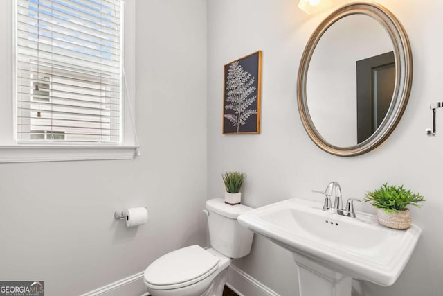 bathroom featuring sink, a healthy amount of sunlight, and toilet