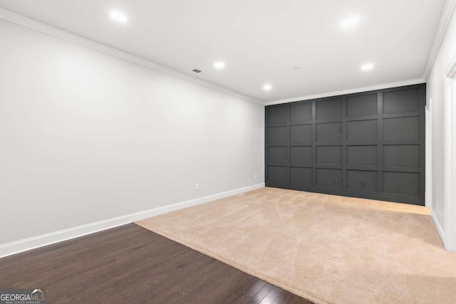 spare room featuring hardwood / wood-style flooring and ornamental molding