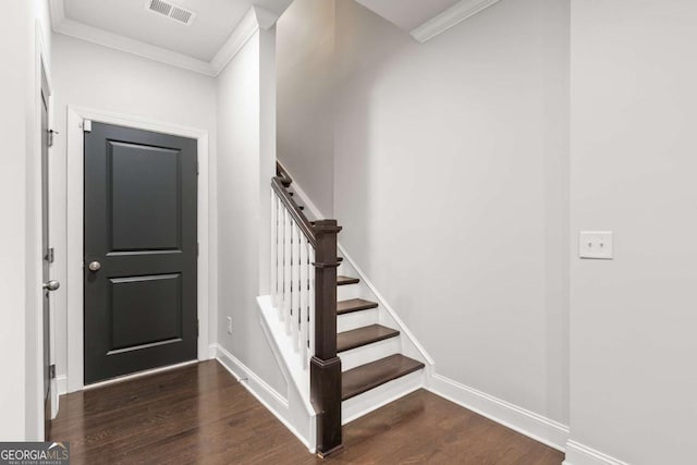 foyer with ornamental molding and dark hardwood / wood-style flooring