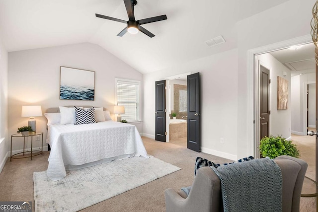 bedroom featuring ceiling fan, light colored carpet, ensuite bath, and vaulted ceiling