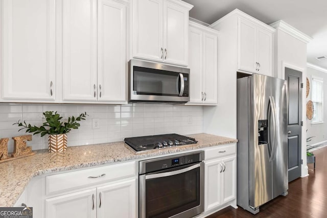 kitchen with light stone counters, tasteful backsplash, white cabinetry, and appliances with stainless steel finishes