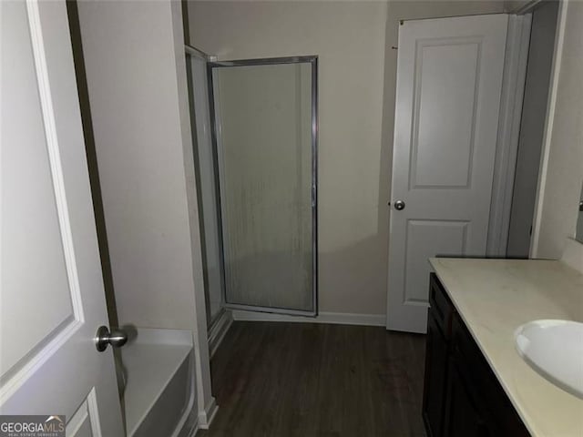 bathroom with hardwood / wood-style floors, vanity, and independent shower and bath