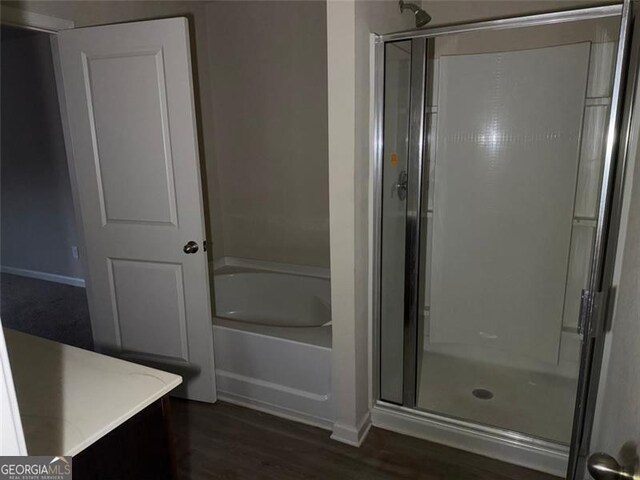 bathroom featuring hardwood / wood-style floors, vanity, and shower with separate bathtub