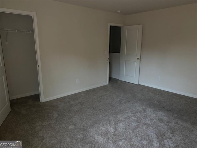 unfurnished bedroom featuring a closet and dark colored carpet