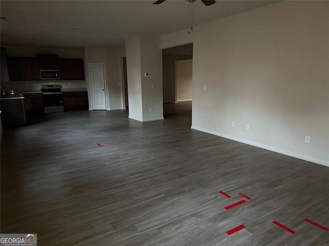 unfurnished living room featuring ceiling fan and dark wood-type flooring