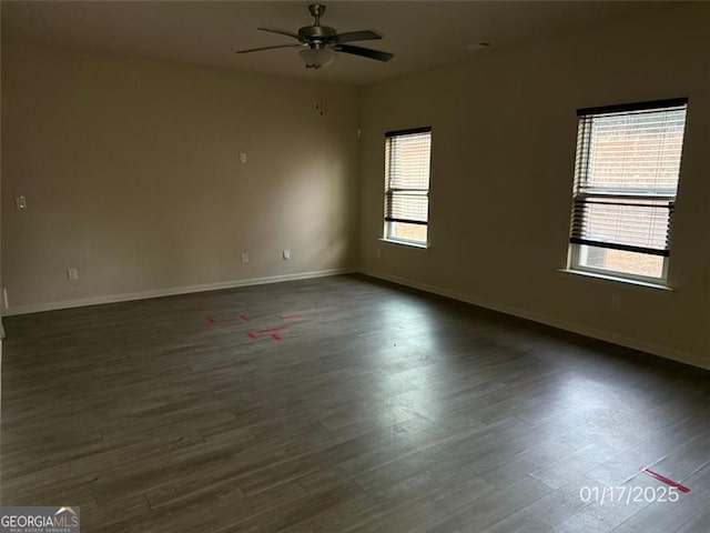 unfurnished room with ceiling fan and dark wood-type flooring