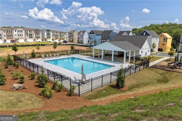 pool with a patio, fence, a gazebo, a yard, and a residential view