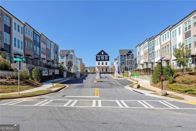 view of street featuring curbs, traffic signs, sidewalks, and a residential view