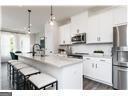 kitchen featuring sink, stainless steel appliances, white cabinetry, and hanging light fixtures