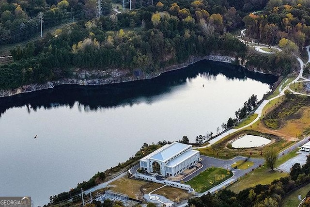 drone / aerial view with a forest view and a water view