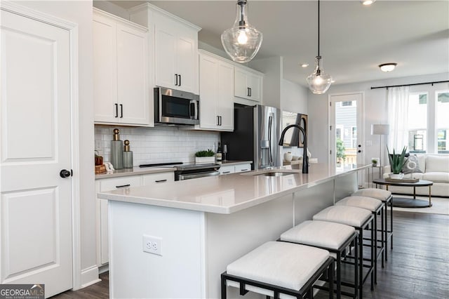 kitchen featuring white cabinetry, a center island with sink, appliances with stainless steel finishes, and a sink