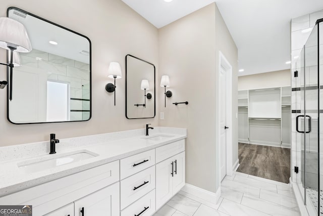 bathroom with vanity and a shower with door