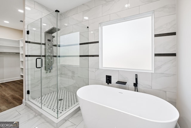 bathroom with independent shower and bath and tile walls