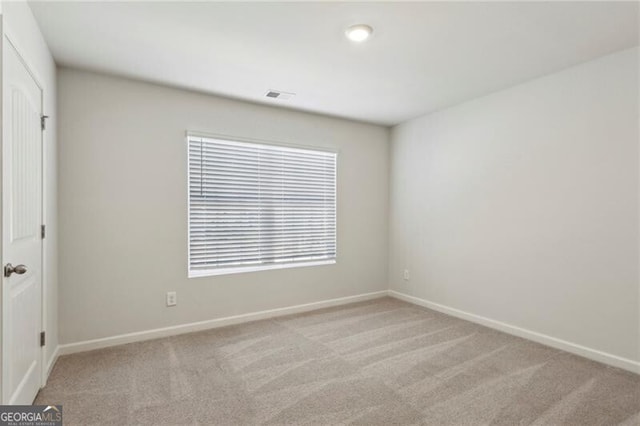 unfurnished room featuring light carpet