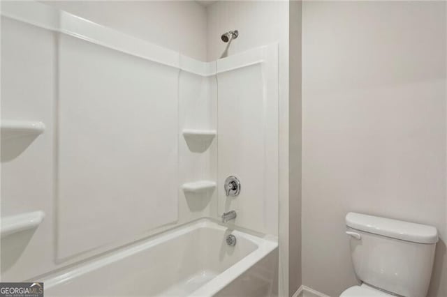 bathroom with tub / shower combination and toilet