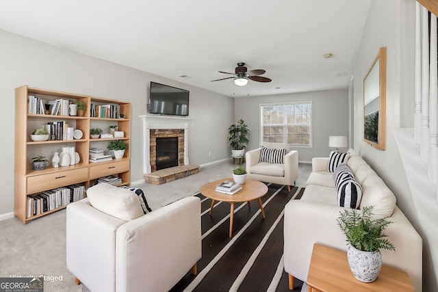 carpeted living room featuring ceiling fan and a fireplace