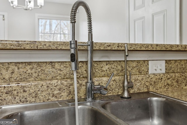 interior details with tasteful backsplash, sink, and a chandelier