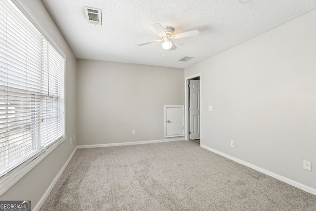 carpeted empty room with a textured ceiling and ceiling fan