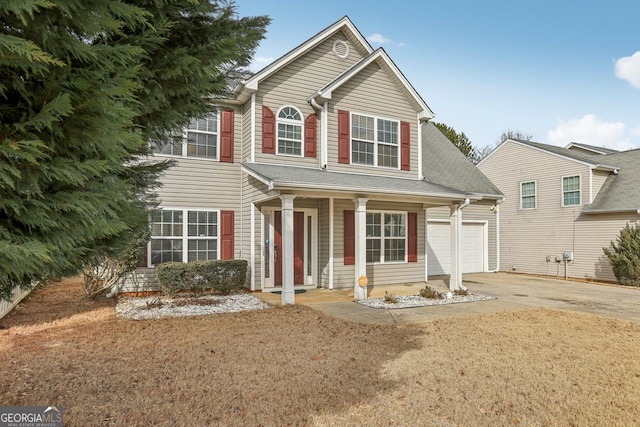 view of front of home featuring a garage, covered porch, and a front yard