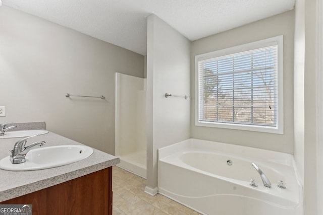 bathroom with vanity, independent shower and bath, and a textured ceiling