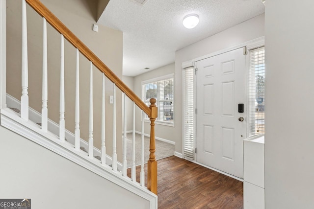 entrance foyer featuring dark wood-type flooring and a textured ceiling