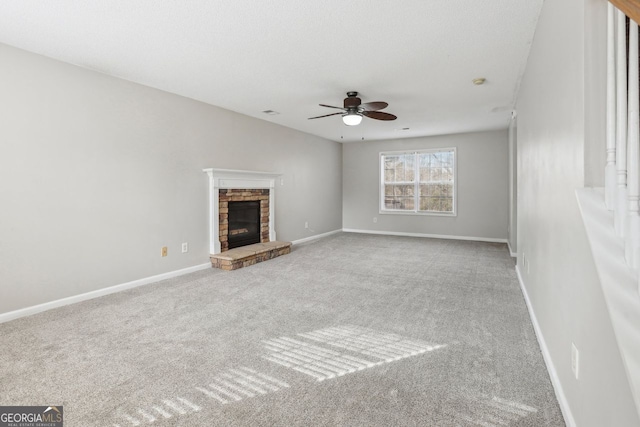 unfurnished living room featuring ceiling fan, light colored carpet, and a fireplace