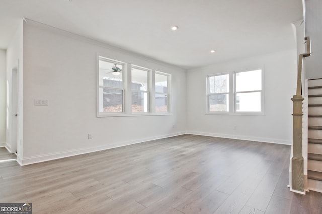 unfurnished living room with ornamental molding and light wood-type flooring