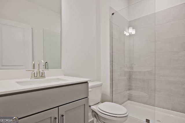 bathroom featuring vanity, toilet, and a shower with door