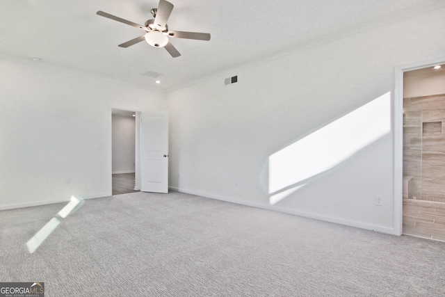 spare room featuring light colored carpet, ceiling fan, and ornamental molding