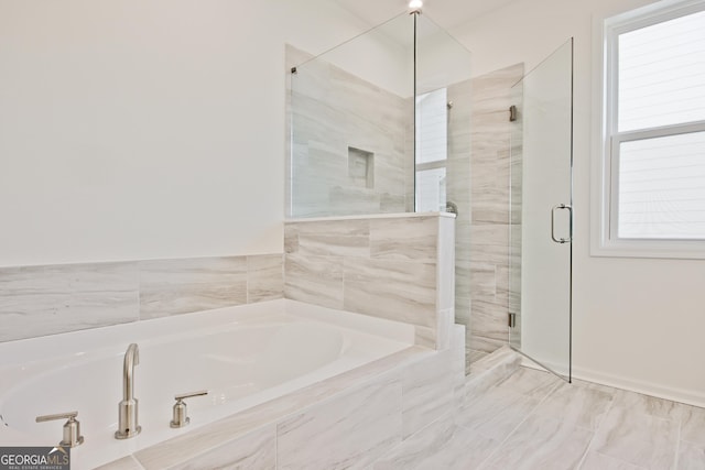 bathroom featuring a healthy amount of sunlight and shower with separate bathtub