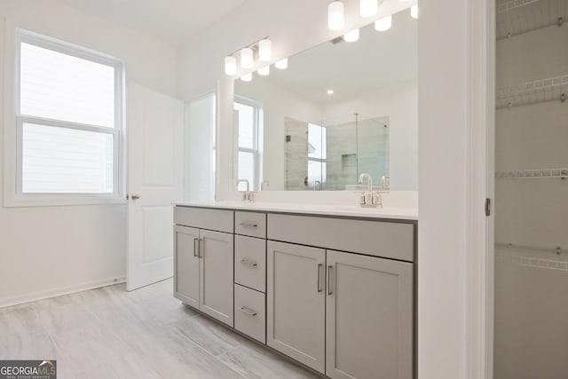 bathroom featuring a wealth of natural light, walk in shower, and vanity