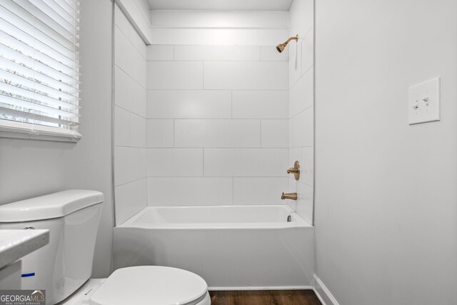 bathroom with shower / bathing tub combination, wood-type flooring, and toilet