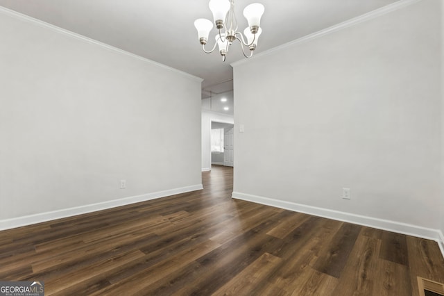 empty room with dark hardwood / wood-style flooring, ornamental molding, and an inviting chandelier