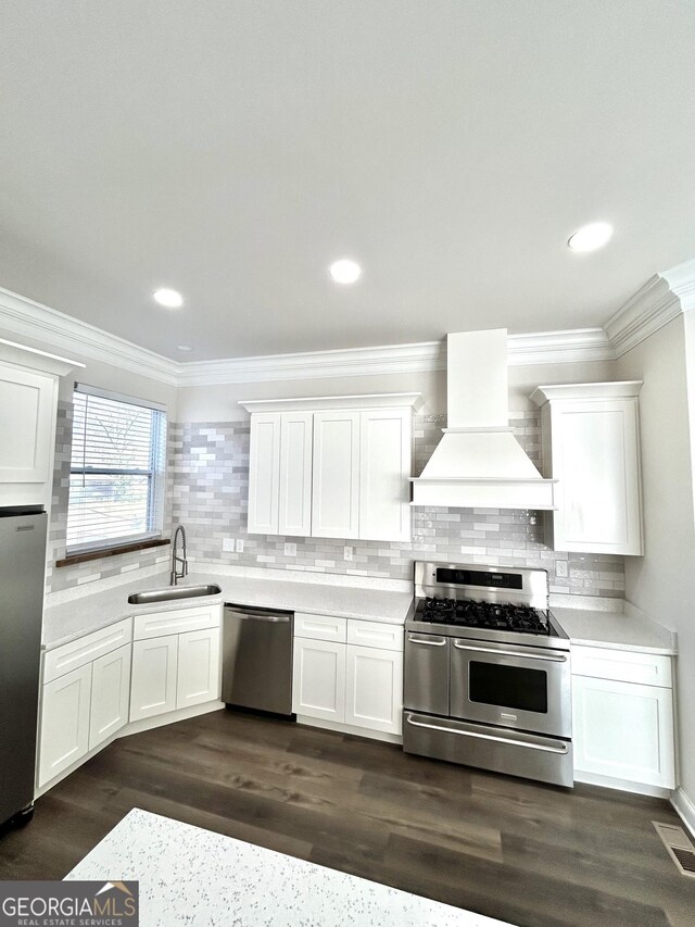 kitchen featuring wood-type flooring, sink, a kitchen island, backsplash, and stainless steel appliances