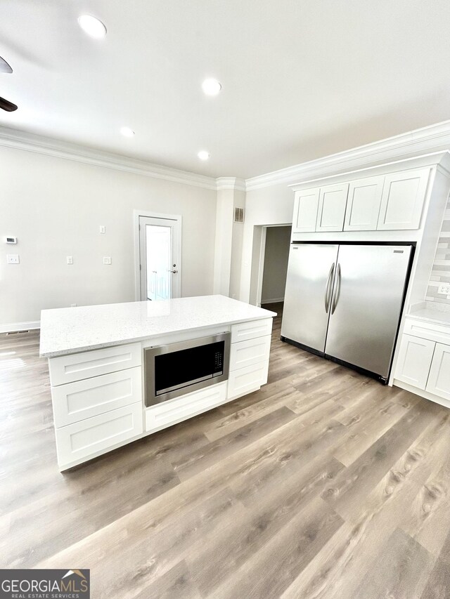 kitchen featuring crown molding, dark hardwood / wood-style flooring, dark brown cabinetry, and appliances with stainless steel finishes