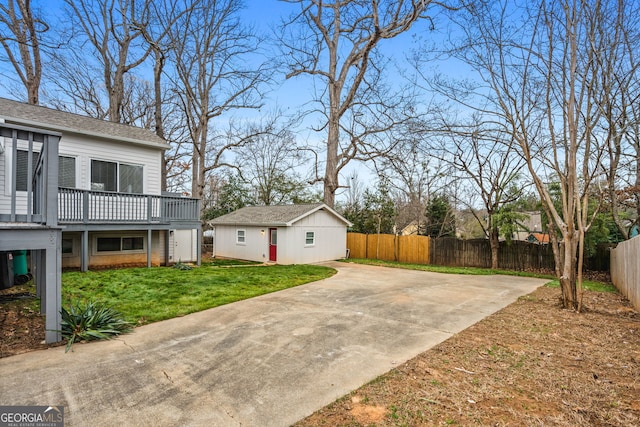 exterior space with a deck, a lawn, and an outbuilding