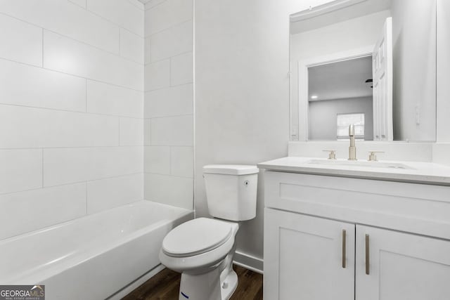 full bathroom with hardwood / wood-style flooring, toilet, vanity, and tiled shower / bath combo