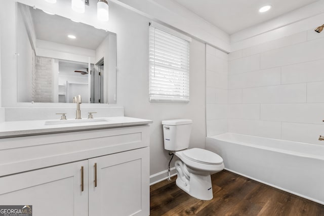 full bathroom featuring hardwood / wood-style flooring, toilet, shower / tub combination, and vanity