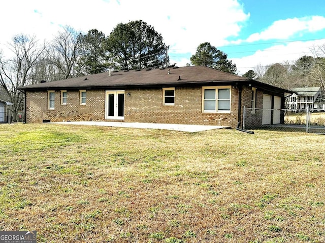 rear view of house featuring a patio area, a lawn, and french doors