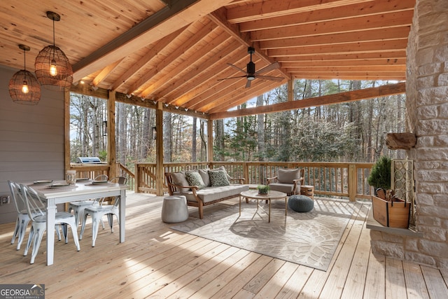 unfurnished sunroom featuring ceiling fan, a wealth of natural light, and lofted ceiling with beams