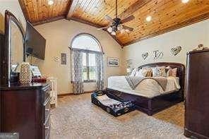 bedroom with wood ceiling, ceiling fan, and lofted ceiling with beams