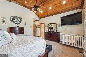 bedroom with vaulted ceiling with beams and wooden ceiling