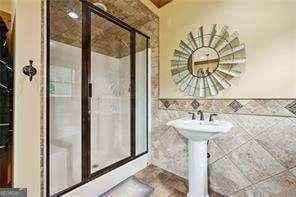 bathroom featuring an enclosed shower and tile walls