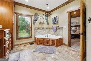 bathroom featuring a washtub and crown molding