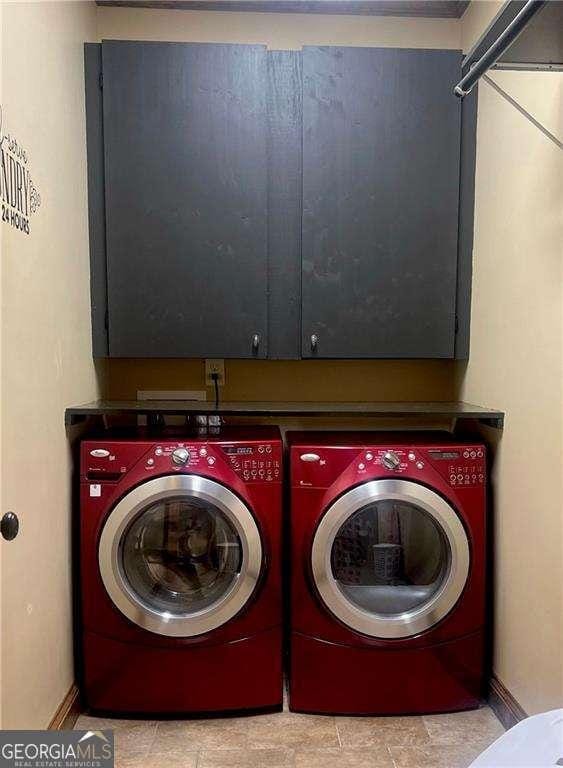 laundry area with washer and dryer and cabinets