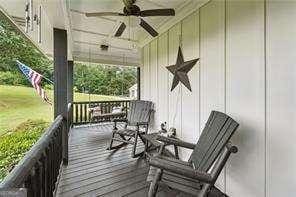 wooden deck featuring covered porch and ceiling fan